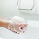 Waschen der Hände mit Seife im Badezimmer. Hygiene