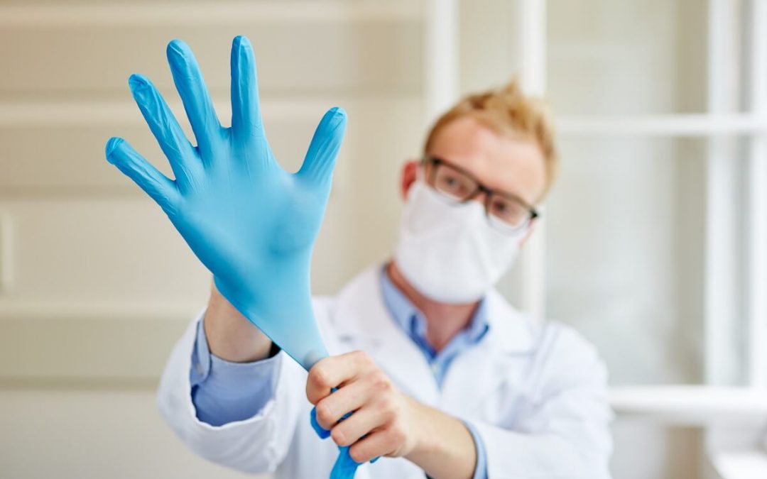 Arzt zieht sich Handschuhe an
